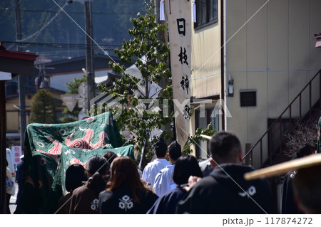 日本の岐阜県高山市　春の高山祭　横笛の一種の篠笛を吹く人達　法被を着ている後ろ姿 117874272