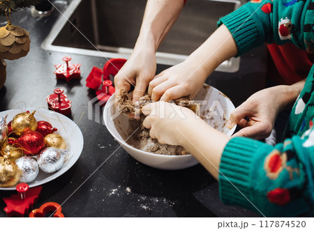 Hands kneading Christmas cookie dough, holiday baking, festive kitchen, family traditions, seasonal preparations, Christmas activities, bonding moments. Hands kneading Christmas cookie dough, holiday baking, festive kitchen, family traditions, seasonal preparations, Christmas activities, bonding moments. 117874520