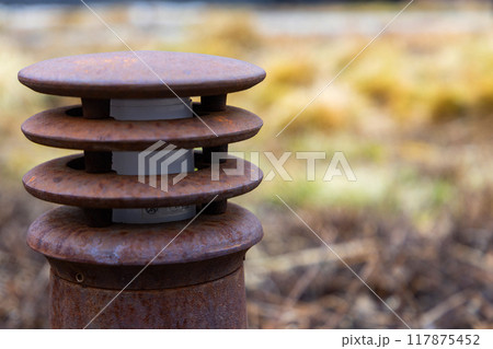 Rusty Industrial Vent in Overgrown Field on a Misty Autumn Morning 117875452
