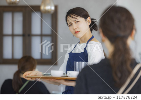案内をするカフェの店員　 117876224