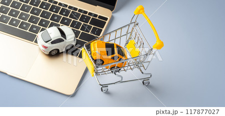 Car toy on laptop with shopping cart on blue background, copy space 117877027