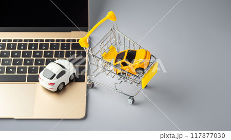 Online buying, selling car concept, toy car on laptop with shopping cart on grey table Online buying, selling car concept, toy car on laptop with shopping cart on grey table 117877030