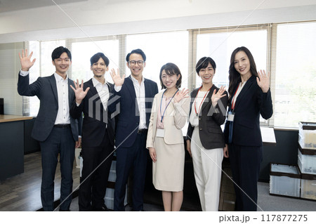 オフィスで手を振るスタッフ6人の集合写真 117877275