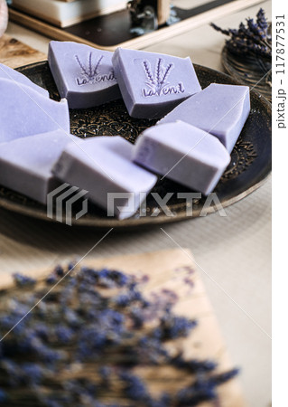 Close-up of handmade lavender soap bars with engraved design on tray. Natural skincare, artisan soap, organic beauty, sustainable living, eco-friendly concept 117877531