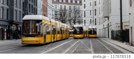 Scenic evening view many modern yellow tram car parked at street station Berlin Mitte central district at dusk warm sunset. Urban european transport commute cityscape Germany scene background 117878318