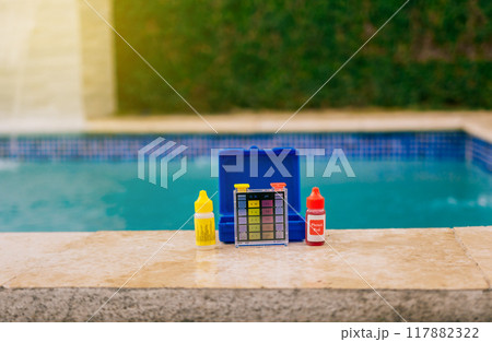 Water test kit for swimming pools. Chlorine and ph tester for swimming pools, Chlorine test kit on the edge of the pool. PH tester for pool maintenance. 117882322