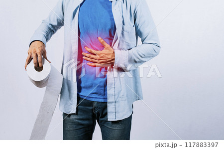 Man with stomach problems holding toilet paper, Person with toilet paper with stomach problems on isolated background, Concept of a person with digestive problems 117883397
