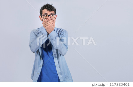 Surprised man covering his mouth looking to the side, Surprised man in glasses covering his mouth looking to the side, concept of man keeping a secret Surprised man covering his mouth looking to the side, Surprised man in glasses covering his mouth looking to the side, concept of man keeping a secret 117883401
