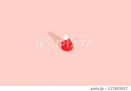 Toy mini hat on a pink background with long shadows. Clothes winter sale concept Toy mini hat on a pink background with long shadows. Clothes winter sale concept 117883627