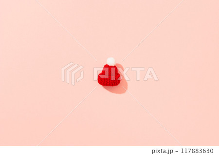 Toy mini hat on a pink background with long shadows. Clothes winter sale concept. Toy mini hat on a pink background with long shadows. Clothes winter sale concept. 117883630