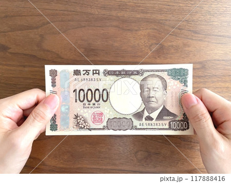 一万円札を持つ女性の手元 117888416