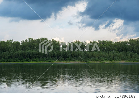 Serene landscape of forest and calm lake, with reflections of trees on the water. Serene landscape of forest and calm lake, with reflections of trees on the water. 117890168