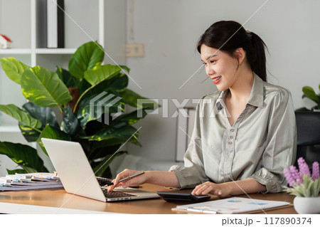 Business accountant use laptop to view company report graph and use calculator to calculate money in company report 117890374