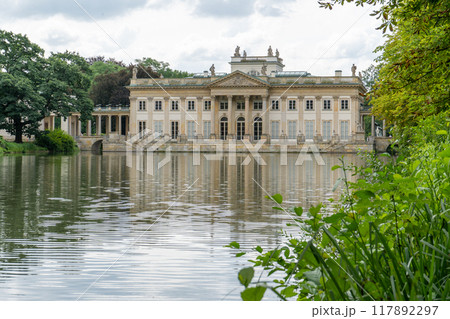 Lazienki Park with pond. Polish Lazienkowski or Lazienki Krolewskie is the polish park. The palace on the water is a monument of architecture. Lazienki Park with pond. Polish Lazienkowski or Lazienki Krolewskie is the polish park. The palace on the water is a monument of architecture. 117892297