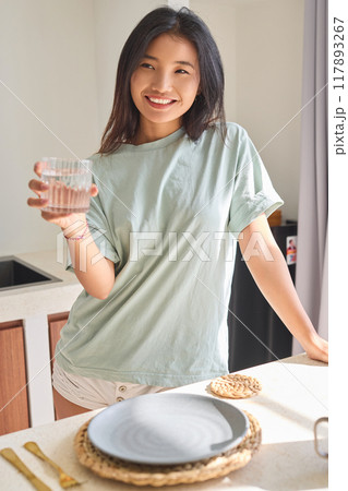 Drink Water. Woman Holding Glass Of Water in Bright Kitchen Atmosphere Drink Water. Woman Holding Glass Of Water in Bright Kitchen Atmosphere 117893267