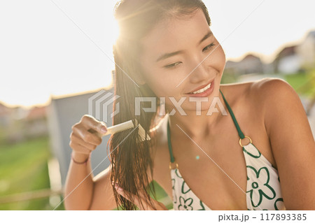 Hair. Woman Enjoying Outdoor Hair Care Routine in Sunlight Hair. Woman Enjoying Outdoor Hair Care Routine in Sunlight 117893385