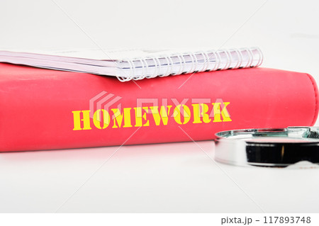 Word HOMEWORK on the end of a business book, notebook on a white background 117893748