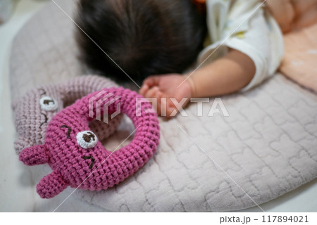 手編みのガラガラと新生児の手 117894021