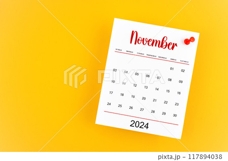 November 2024 calendar page with red push pin on yellow background. November 2024 calendar page with red push pin on yellow background. 117894038