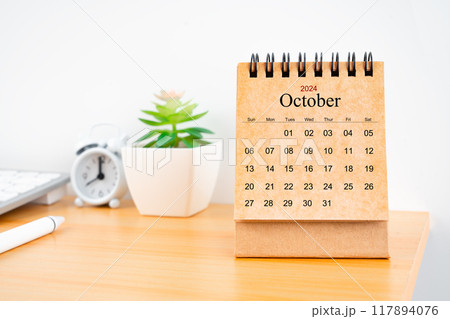 October 2024 desk calendar on worktable. October 2024 desk calendar on worktable. 117894076