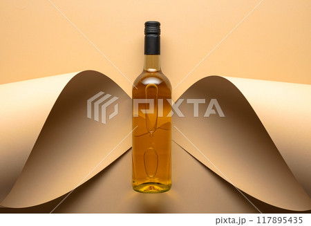 Bottle of white wine on a beige background. 117895435