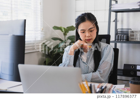 Businesswoman sitting at desk on couch in workplace Businesswoman sitting at desk on couch in workplace 117896377