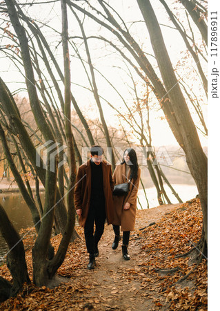 Young couple in love walking in the park on a autumn day. Enjoying time together. 117896911