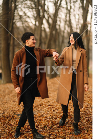 Young couple in love walking in the park on a autumn day. Enjoying time together. 117896923