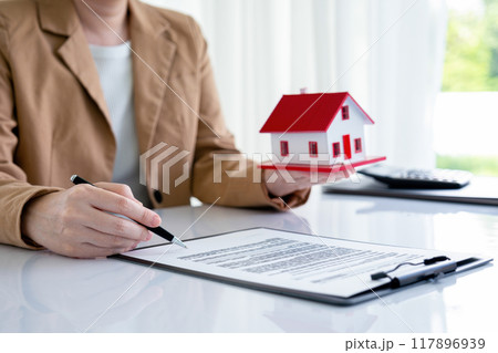 Real estate agent negotiating contract with buyer. 117896939