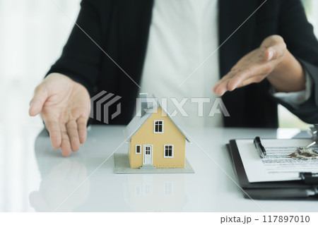 Real estate agent handing house model Real estate agent handing house model 117897010