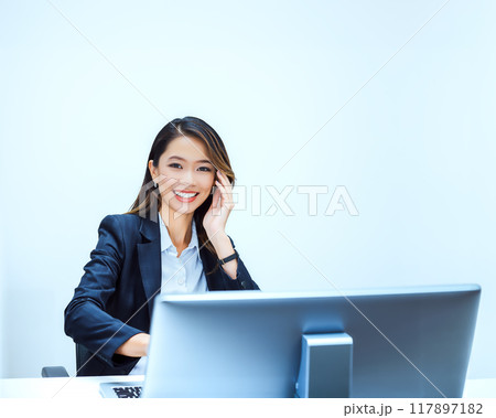 オフィスで仕事をする笑顔の女性のイメージ素材 117897182