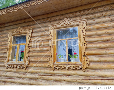 Wooden carved window frames, decorative elements of cornice of exhibition house, built on site of annual national Tatar holiday Sabantuy, in walking park with free access around clock, all year round Wooden carved window frames, decorative elements of cornice of exhibition house, built on site of annual national Tatar holiday Sabantuy, in walking park with free access around clock, all year round 117897412