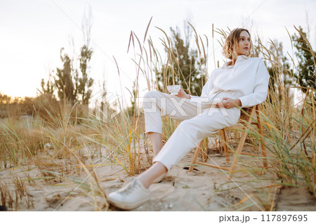 Stylish woman enjoying autumn weather outdoor. Fashion, style concept. People, lifestyle, relaxation Stylish woman enjoying autumn weather outdoor. Fashion, style concept. People, lifestyle, relaxation 117897695