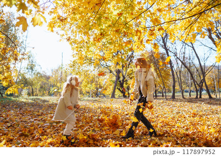 Stylish mother and daughter enjoy the autumn park. Family on a walk. Childhood, walks, rest. Stylish mother and daughter enjoy the autumn park. Family on a walk. Childhood, walks, rest. 117897952