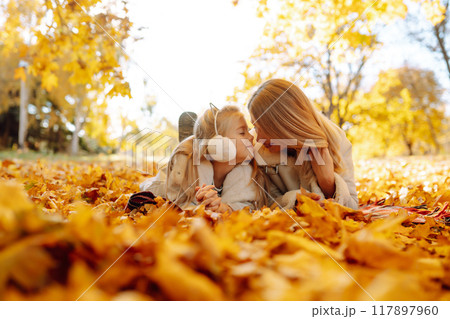 Stylish mother and daughter enjoy the autumn park. Family on a walk. Childhood, walks, rest. Stylish mother and daughter enjoy the autumn park. Family on a walk. Childhood, walks, rest. 117897960