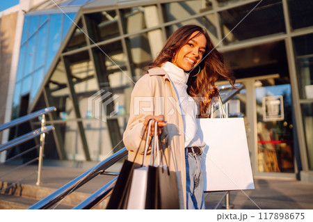 Young woman with shopping bags. Consumerism, purchases, shopping, lifestyle, sale concept. 117898675
