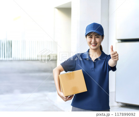 小荷物を運ぶ笑顔の女性宅配業者のイメージ素材 小荷物を運ぶ笑顔の女性宅配業者のイメージ素材 117899092