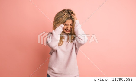 Woman gesturing headache hands on head 117902582