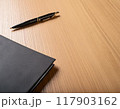 デスクに雑然と置かれた手帳とペン 117903162