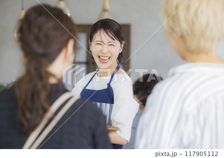 案内をするカフェの店員　 117905112