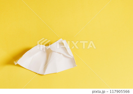 Remains of a plastic glass on a yellow background. 117905566