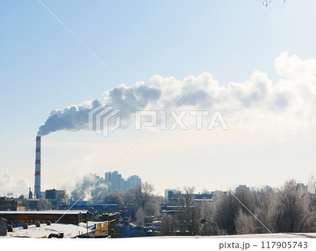 View of a winter city with a smoking chimney. 117905743