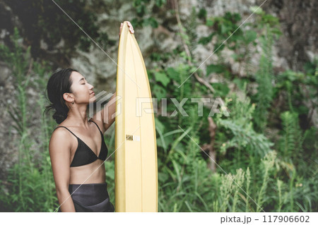 サーフボードを持って自然の中にいる若い女性 サーフボードを持って自然の中にいる若い女性 117906602