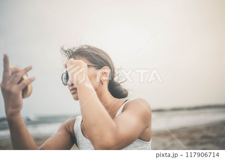 海辺でスキンケアをする若い女性 117906714