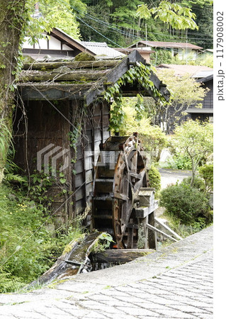 宿場町の古い町並み 新緑が美しい街道沿いの水車小屋と水車 117908002