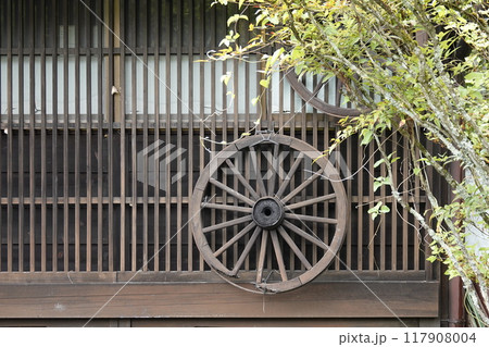 宿場町 古民家の格子戸に飾られた木製車輪 117908004