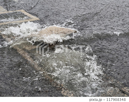 大雨で側溝から溢れる雨水 117908348