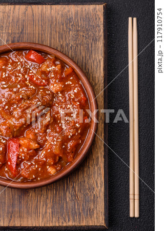 Thai Asian dish with meat, hot pepper, tomato sauce and sesame 117910754