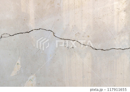 Cracked concrete wall covered with a gray cement surface as a background Cracked concrete wall covered with a gray cement surface as a background 117911655