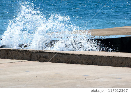 Powerful dynamic waves continuously crash against the pier Powerful dynamic waves continuously crash against the pier 117912367